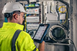 un électricien travaillant dans un tableau de distribution.